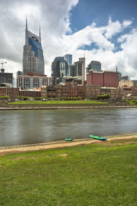 River by buildings against sky in city