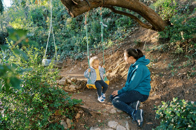 Side view of man sitting on rock