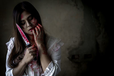 Portrait of young woman with halloween make-up holding axe