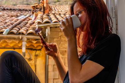 Midsection of woman holding mobile phone