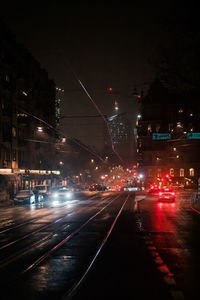 Cars on city street at night