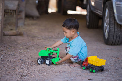 Side view of boy playing with toys on field