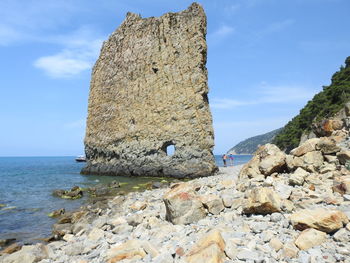 Rocks by sea against sky