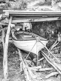 Abandoned boat moored on land