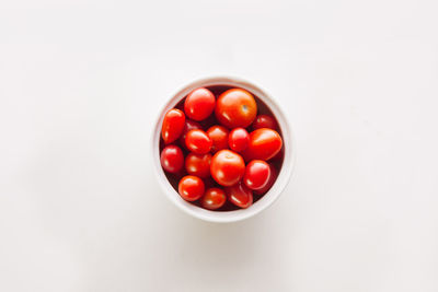 High angle view of tomatoes in bowl against white background