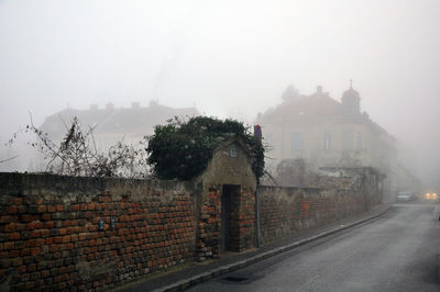 Road by buildings in city during winter