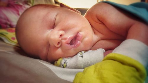 Close-up of baby lying on man