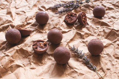 Chocolate round candies on brown crumpled craft paper with lavender flowers