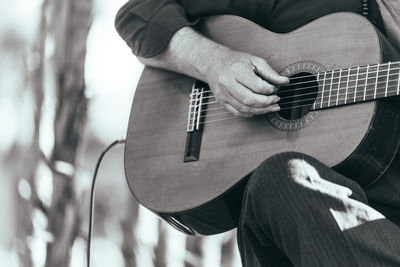 Low section of man playing guitar