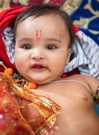 Cute indian boy dresses as lord rama with bow and flowers from top angle