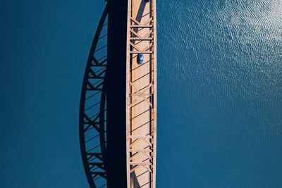 Directly above shot of bridge over sea on sunny day