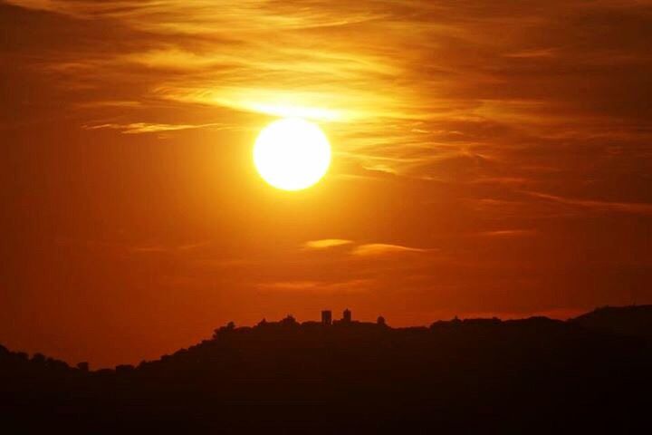 SILHOUETTE OF SUN SHINING THROUGH CLOUDS