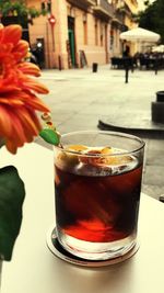 Close-up of red rose in glass on table