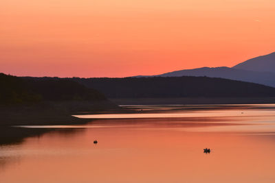 Scenic view of lake against orange sky