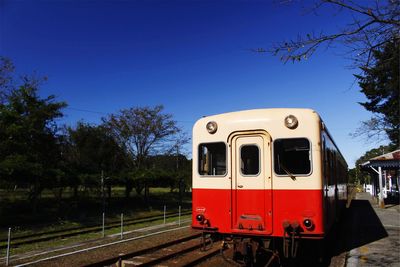 Train on railroad track against clear blue sky