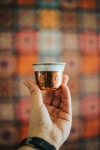 Close-up of hand holding coffee cup