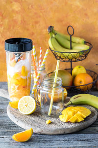 A blender container filled with ingredients to make a citrus mango smoothie.