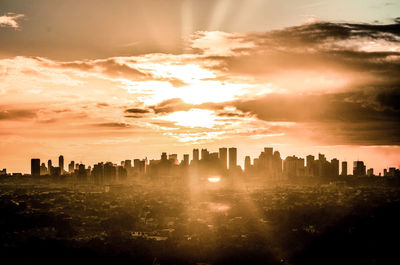 Silhouette buildings against sky during sunset