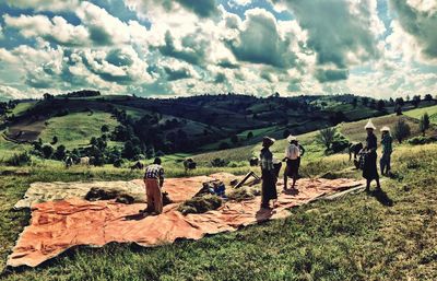 People on agricultural field against sky