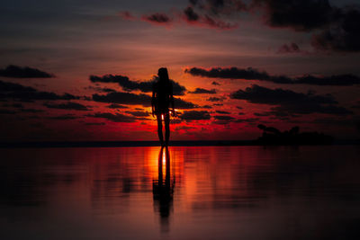 Silhouette man standing at beach during sunset