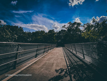 Empty footbridge against sky