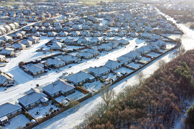 High angle view of snow on city buildings during winter