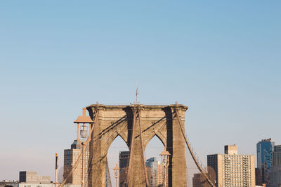 Low angle view of brooklyn bridge against clear sky in city