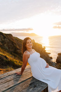 Portrait of smiling woman against sky during sunset