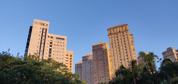 Low angle view of buildings against clear blue sky