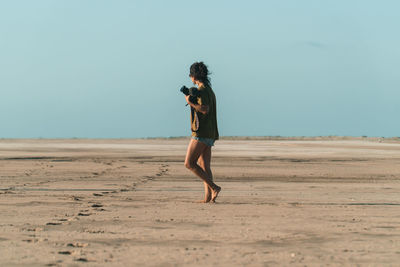 Female photographer in the desert taking photos at golden hour.