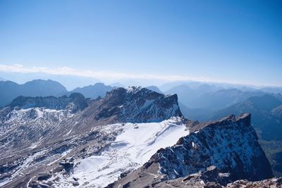 Scenic view of snowcapped mountains against blue sky