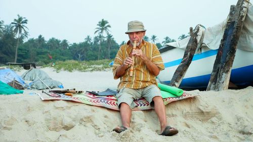 Full length of man sitting on sand