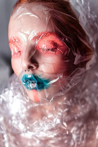 Portrait of a young girl in a transparent film on a white background