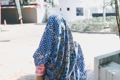 Woman covered with scarf while standing outdoors