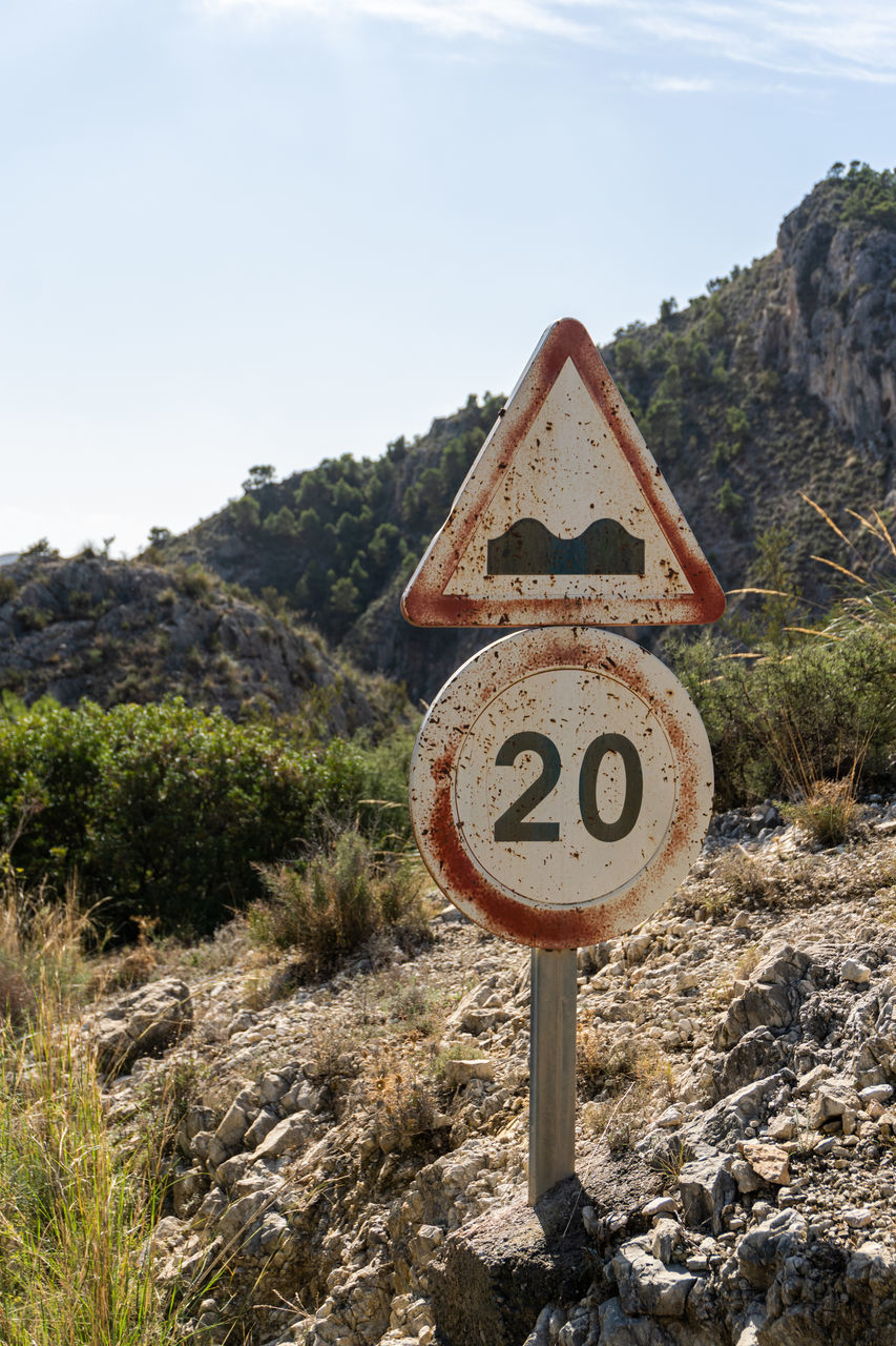 sign, nature, sky, communication, road sign, no people, mountain, plant, road, trail, day, landscape, land, traffic sign, outdoors, scenics - nature, shape, non-urban scene, warning sign, environment, text, information sign, rock, guidance, cloud, number