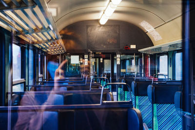 Blurred motion of train, woman reflecting in window