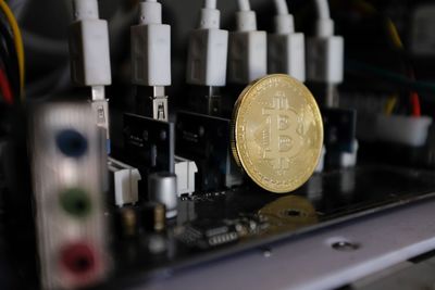 Close-up of bitcoin on circuit board at table
