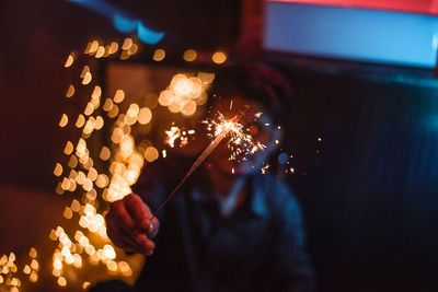 Blurred motion of person holding sparkler at night
