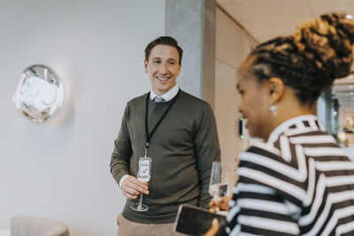 Smiling businessman looking at businesswoman during networking seminar