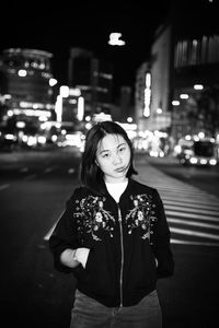 Portrait of woman standing on street at night