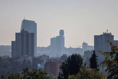 Buildings in city against clear sky