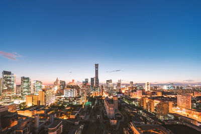 Aerial view of illuminated city buildings against sky