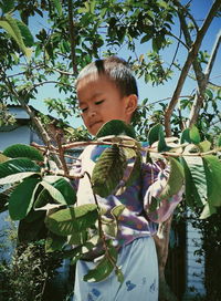 Boy standing by tree