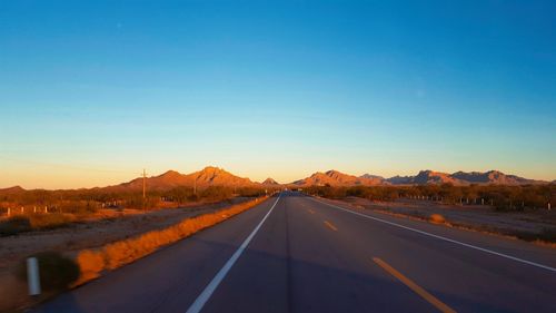 Road against clear blue sky