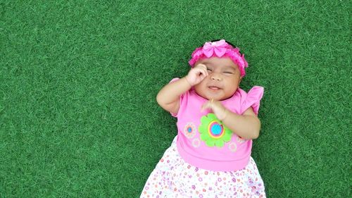 High angle view of baby boy lying on grass