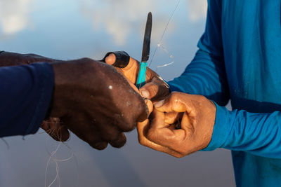 Hands of fishermen untying fishing line. pole fishing.