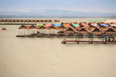 Houses by sea against sky