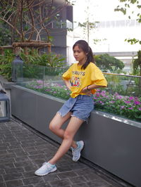 Low angle view of young woman standing against wall