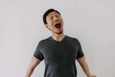 Portrait of young woman standing against white background