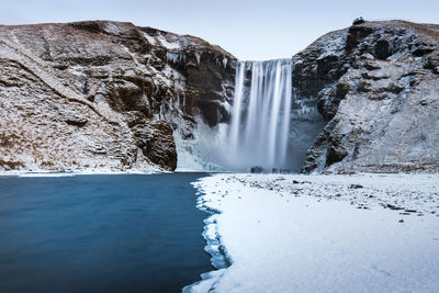 Scenic view of waterfall against sky